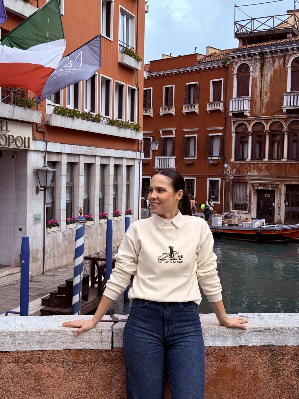 Miriã sorrindo, apoiada numa mureta em frente a um canal de Veneza